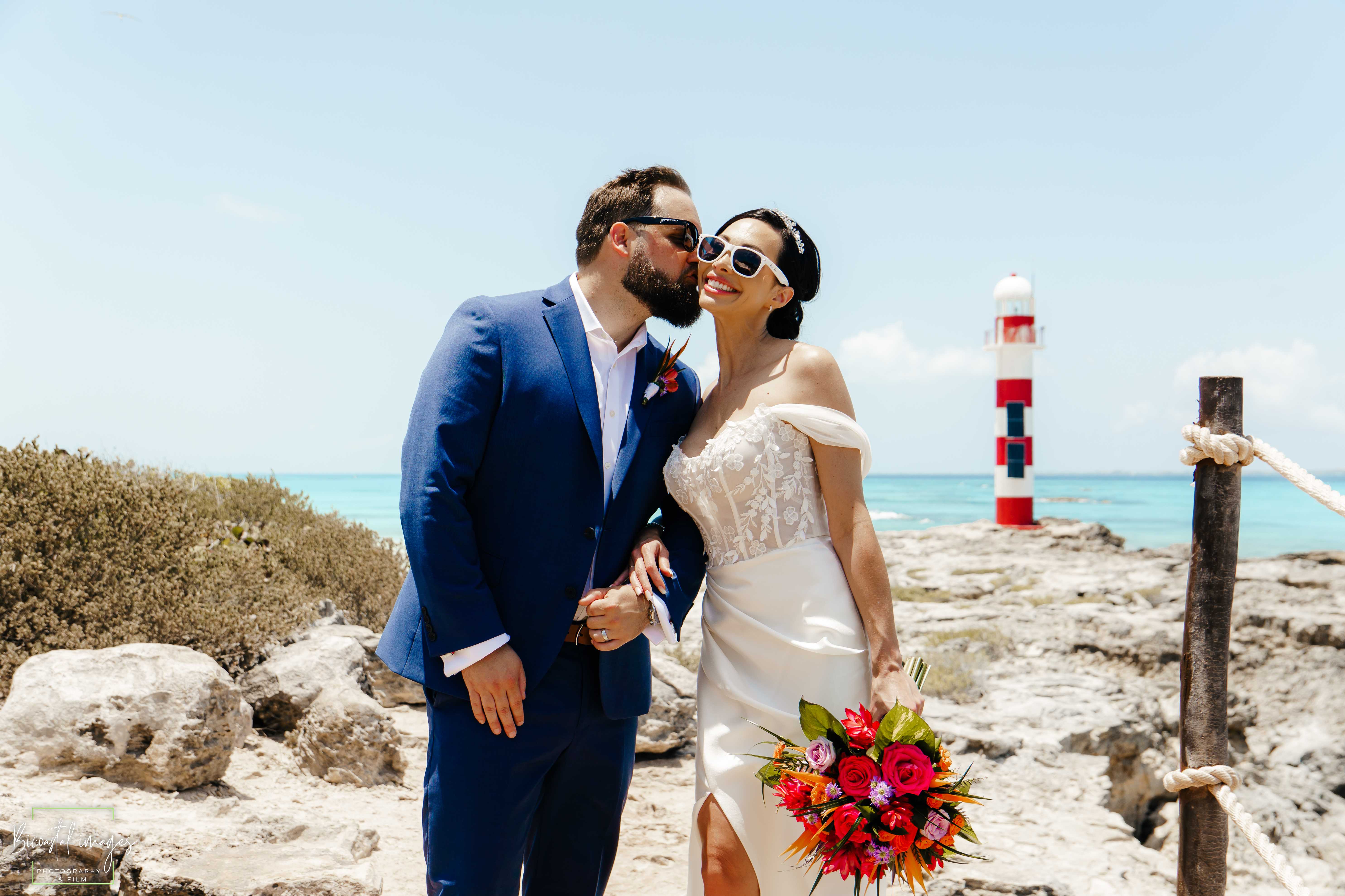 Couple portrait with lighthouse backdrop and vibrant bouquet