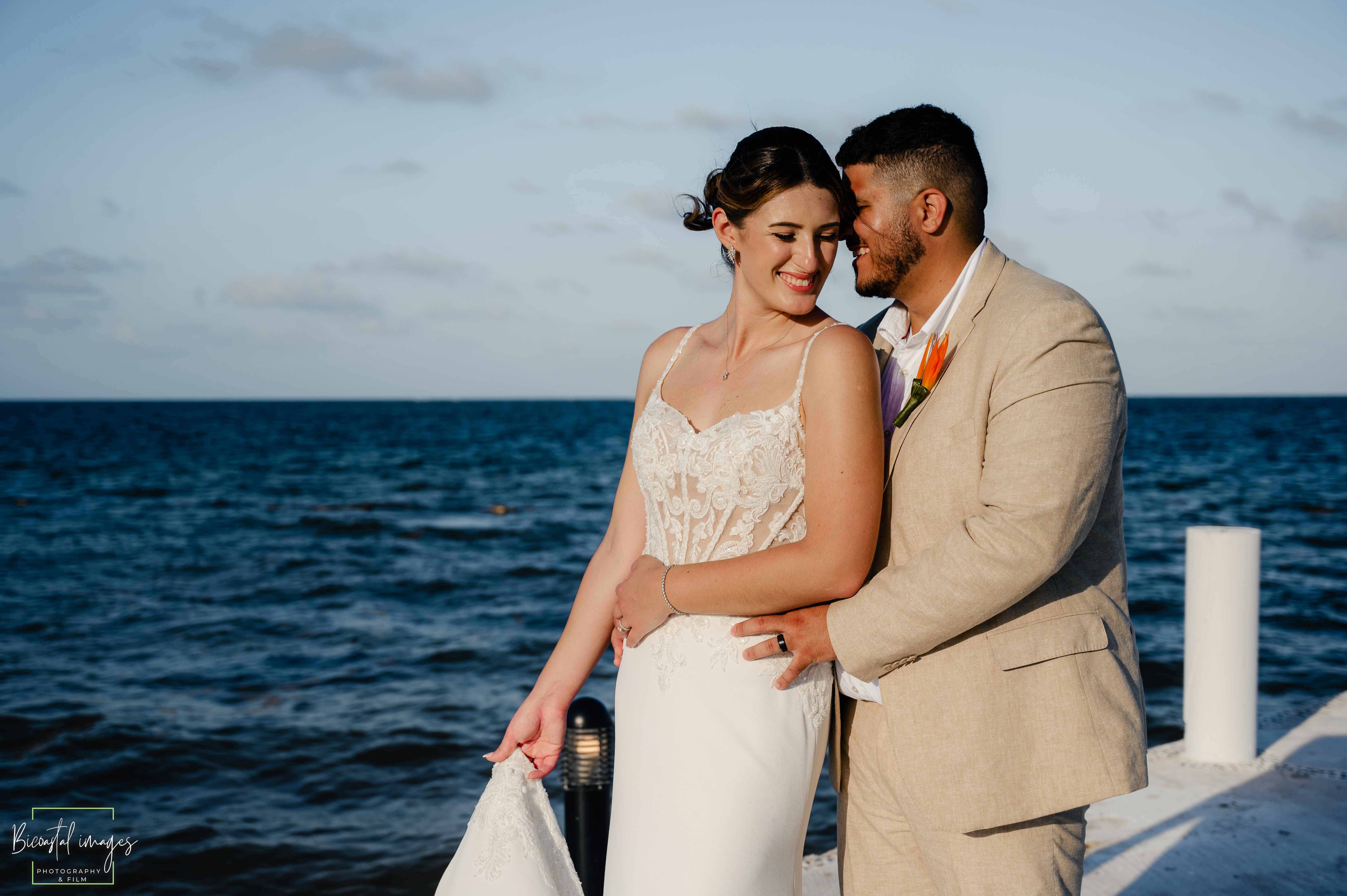 Intimate couple portrait on white pier with deep blue ocean backdrop