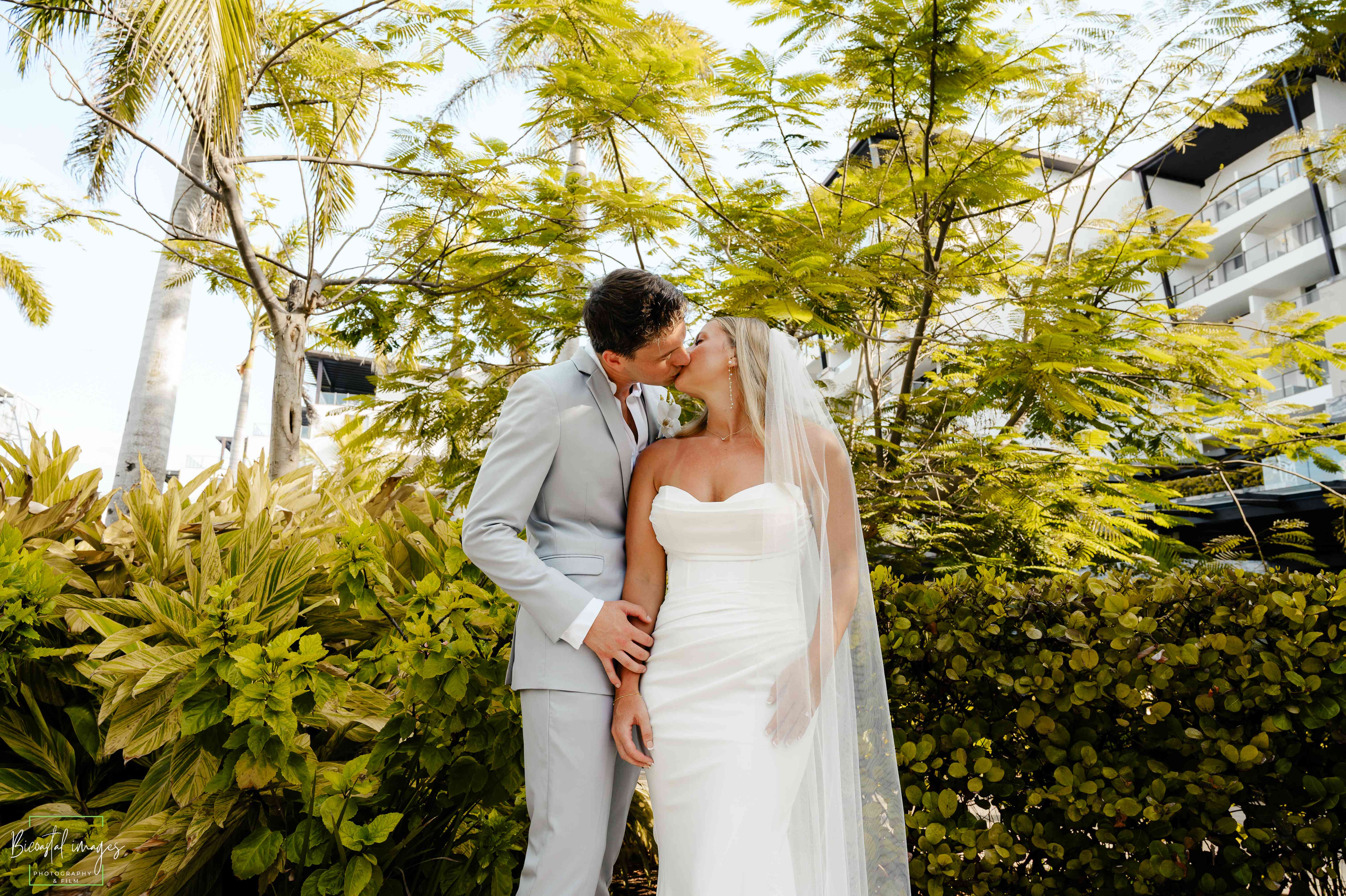 Romantic kiss in tropical garden setting with lush greenery
